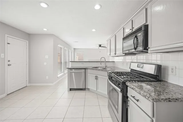 a kitchen with a stove sink and cabinets