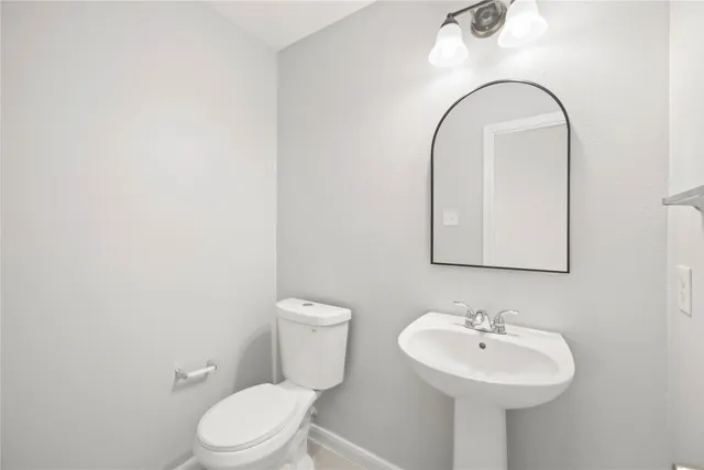 a bathroom with a sink a toilet and mirror