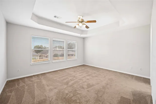 an empty room with windows and fan