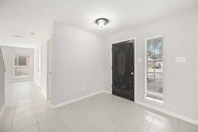 a view of an empty room with cabinet and a window