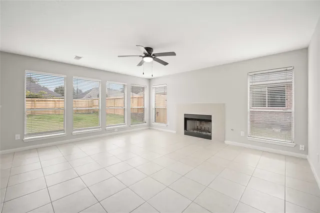 a view of an empty room with a fireplace and a window