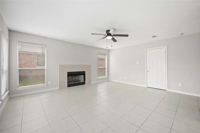 a view of an empty room with a fireplace and a window