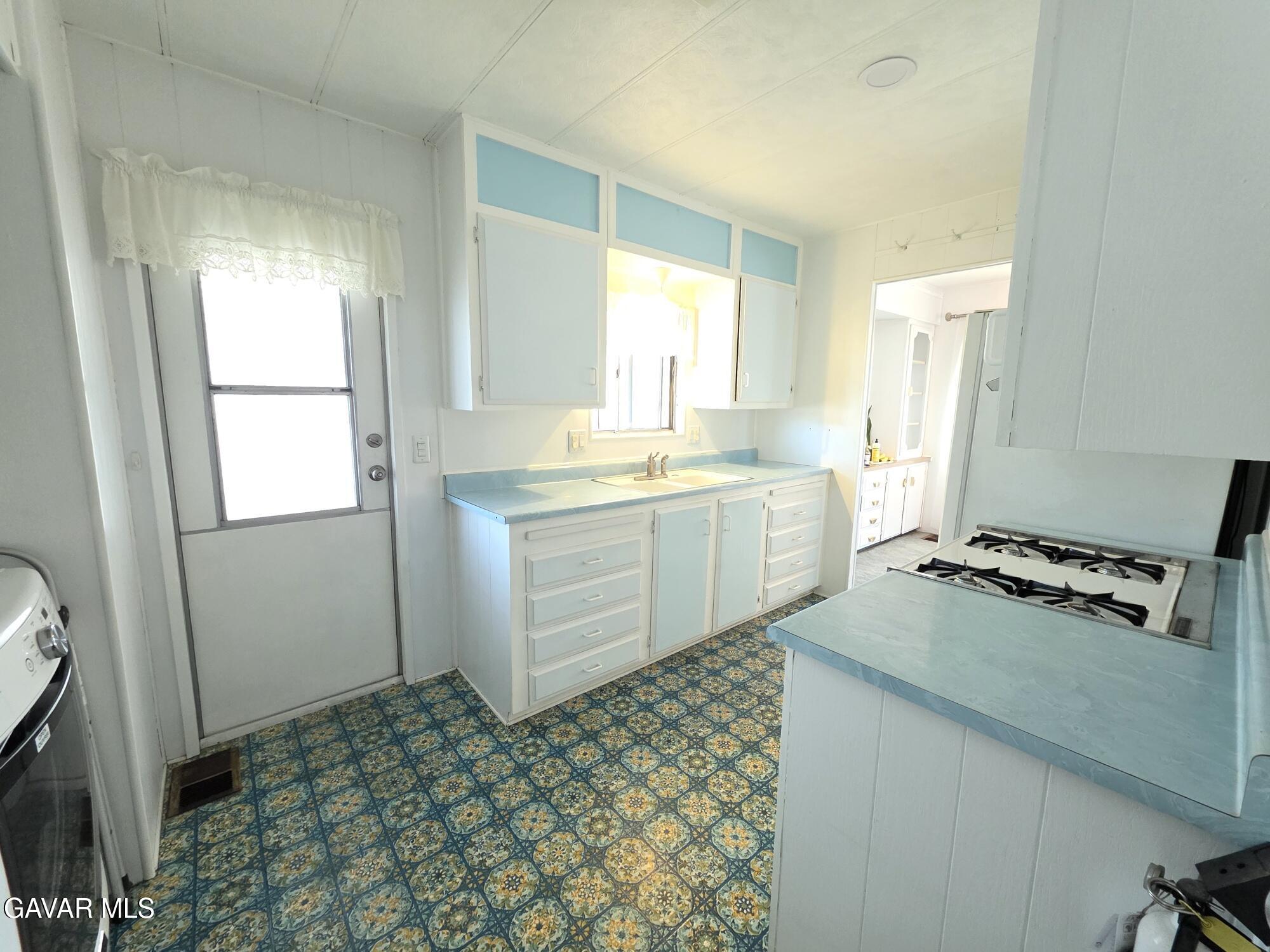 20806 Gridley Road Lakewood, CA 90715 - Photo 20 of 44 a kitchen with a sink stove and cabinets