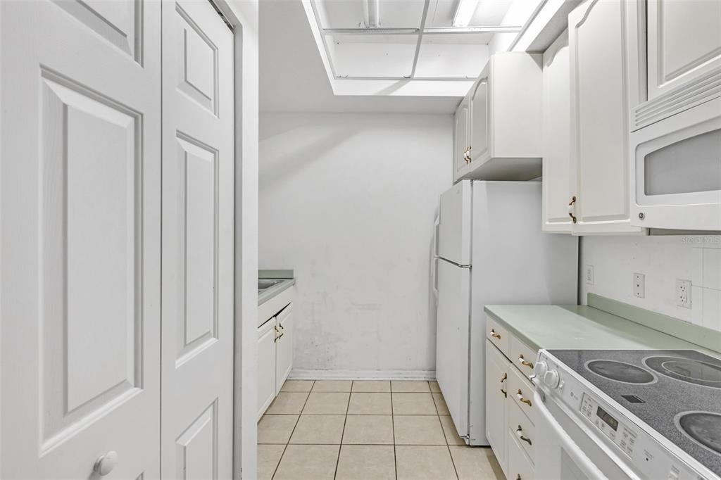 3730 Cadbury Circle, Unit 431 Venice, FL 34293 - Photo 11 of 34 a kitchen with white cabinets and white appliances