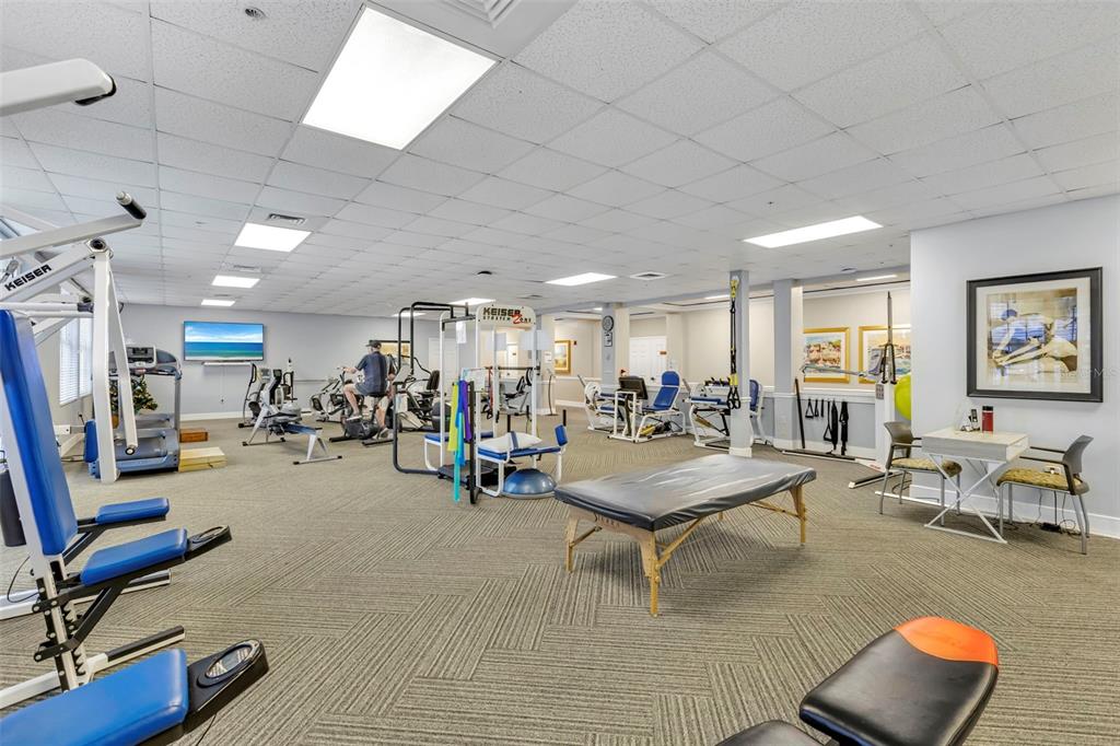 3730 Cadbury Circle, Unit 431 Venice, FL 34293 - Photo 29 of 34 a living room with furniture gym equipment and a flat screen tv