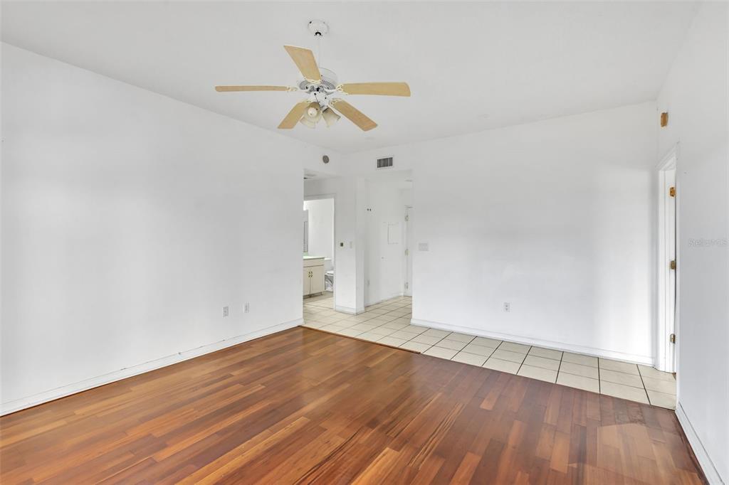3730 Cadbury Circle, Unit 431 Venice, FL 34293 - Photo 9 of 34 an empty room with wooden floor and fan
