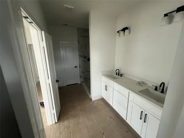 a spacious bathroom with a double vanity sink and a mirror