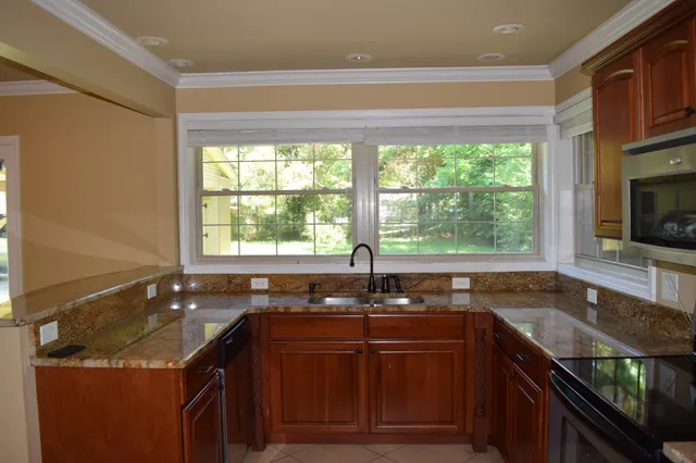 a kitchen with granite countertop a sink and a window