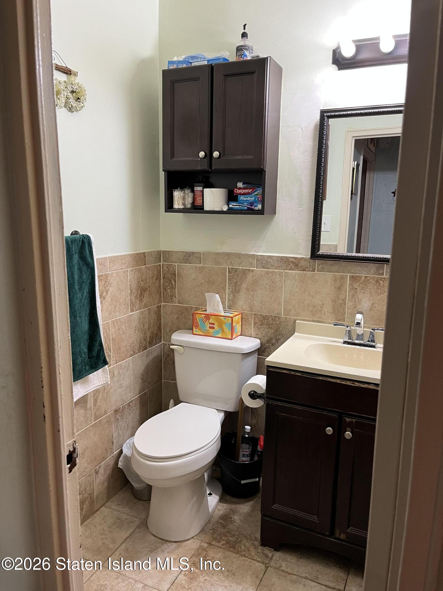 1000 Clove Road, Unit LD Staten Island, NY 10301 - Photo 13 of 21 a bathroom with a toilet a sink and a mirror