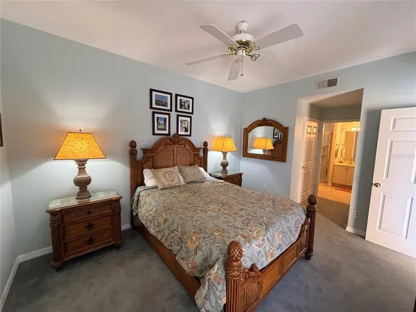 a bedroom with a bed and a flat tv screen on dresser