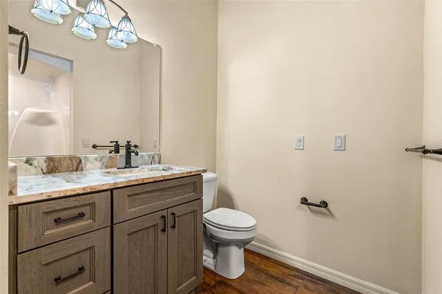 a bathroom with a granite countertop sink a toilet and a mirror