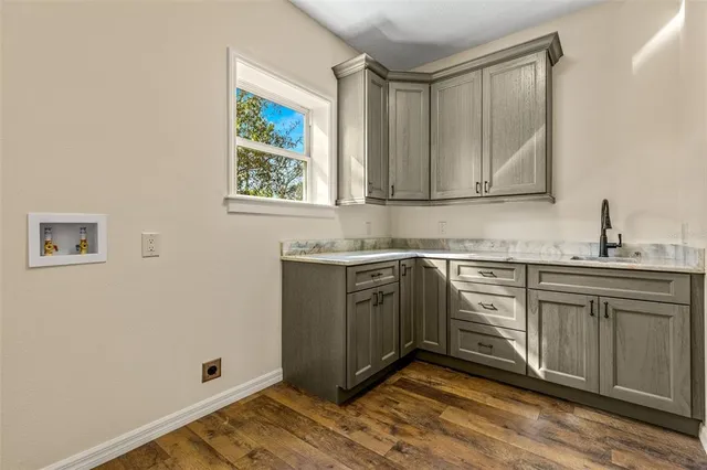 a kitchen with a sink cabinets and wooden floor