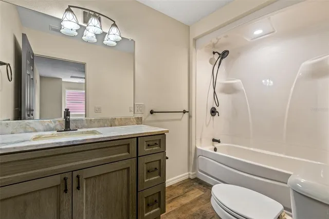 a bathroom with a granite countertop toilet sink and a bathtub
