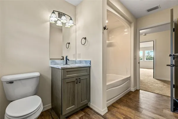 a bathroom with a sink a toilet a mirror and shower