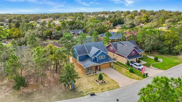 an aerial view of a house with a yard and lake view
