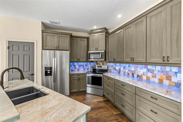 a kitchen with stainless steel appliances granite countertop a refrigerator sink and cabinets