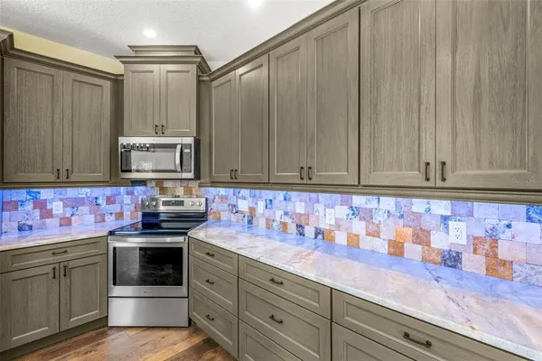 a kitchen with stainless steel appliances granite countertop a sink a stove and cabinets