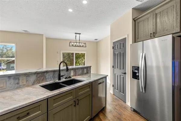 a kitchen with stainless steel appliances a sink stove and refrigerator