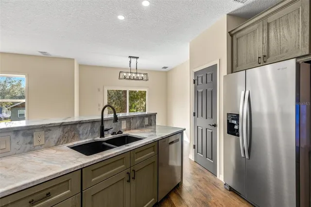 a kitchen with stainless steel appliances a sink stove and refrigerator