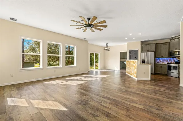 a view of a kitchen with a kitchen island wooden floor and windows