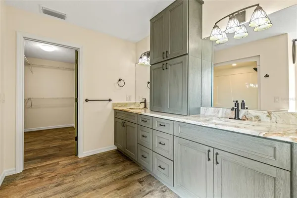 a spacious bathroom with a granite countertop sink a mirror and a shower
