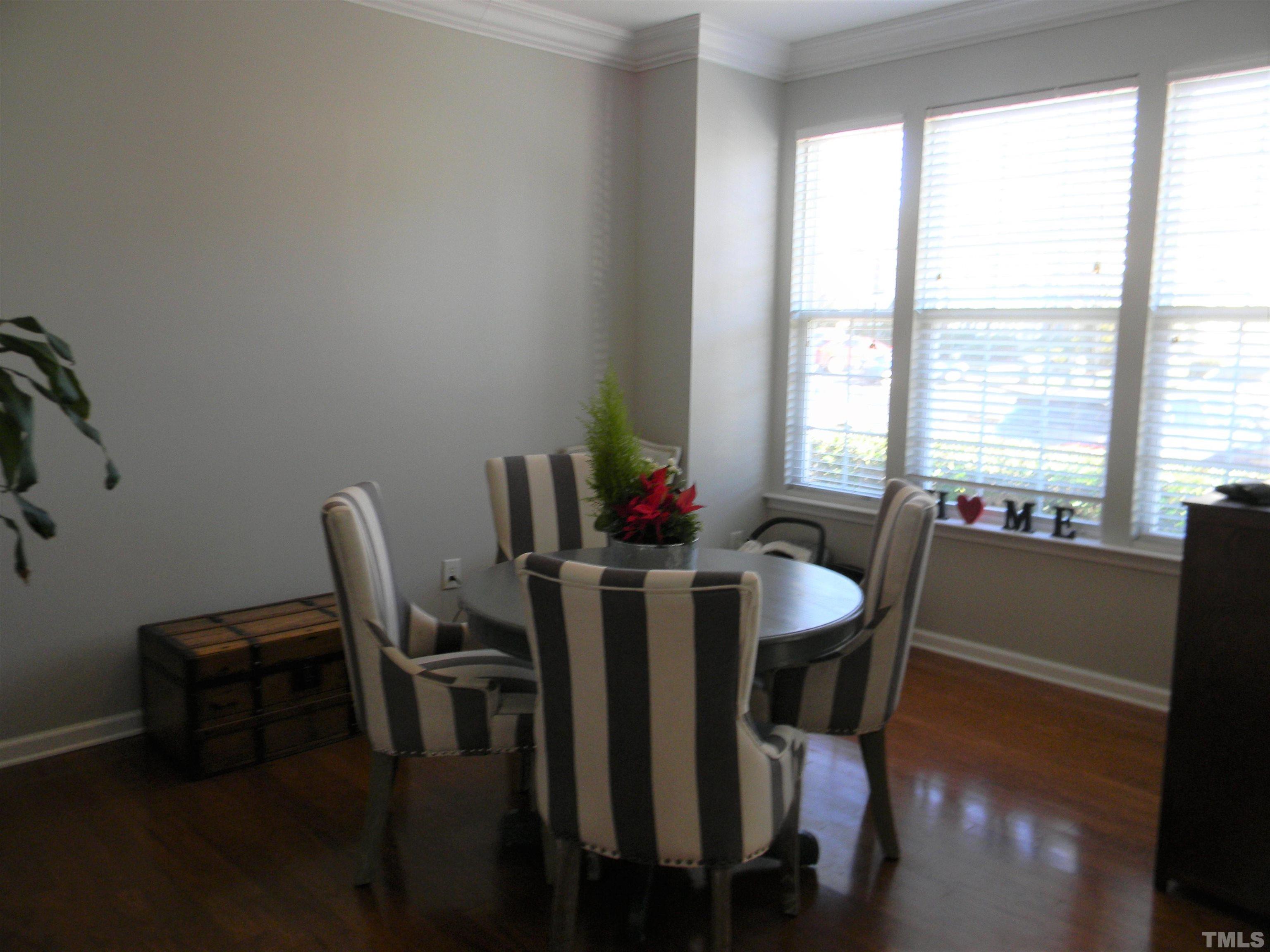7717 Winners Edge Street Raleigh, NC 27617 - Photo 3 of 15 a view of a dining room with furniture and wooden floor