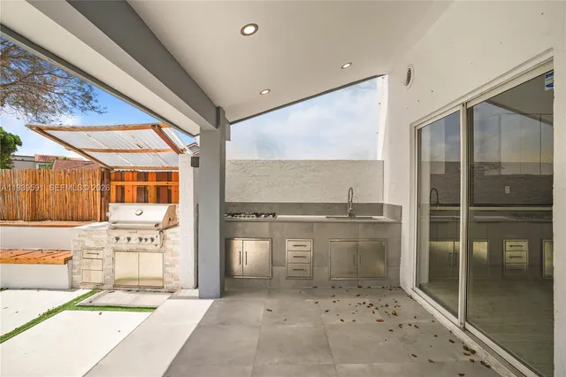 a view of a patio with table and chairs potted plants and floor to ceiling window