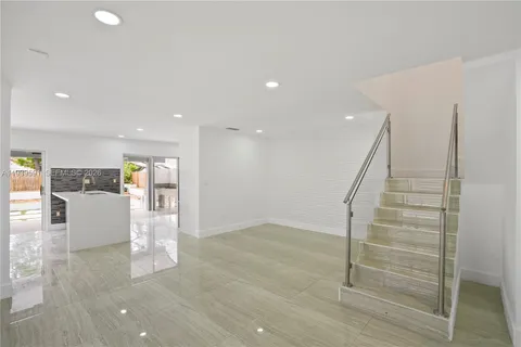 a view of kitchen with kitchen island granite countertop a refrigerator cabinets and a sink