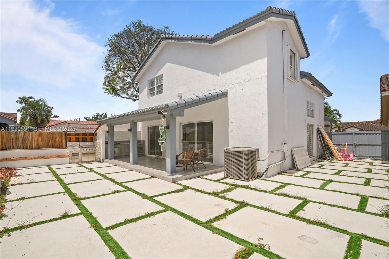 12894 Southwest 60th Terrace Miami, FL 33183 - Photo 52 of 66 a view of a patio with a table and chairs near a yard