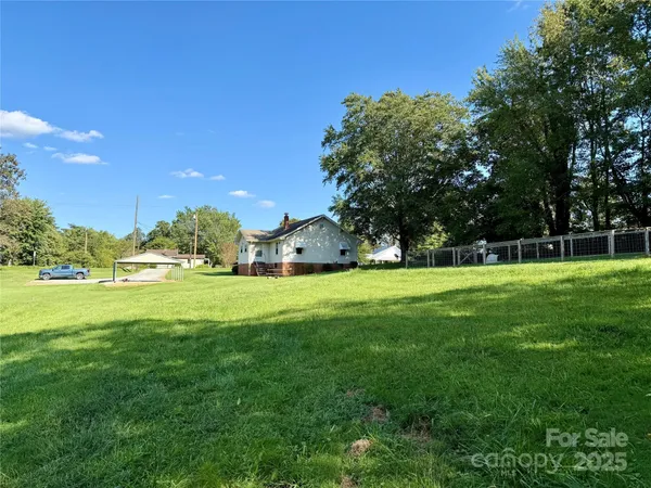 a view of a yard with a wooden fence