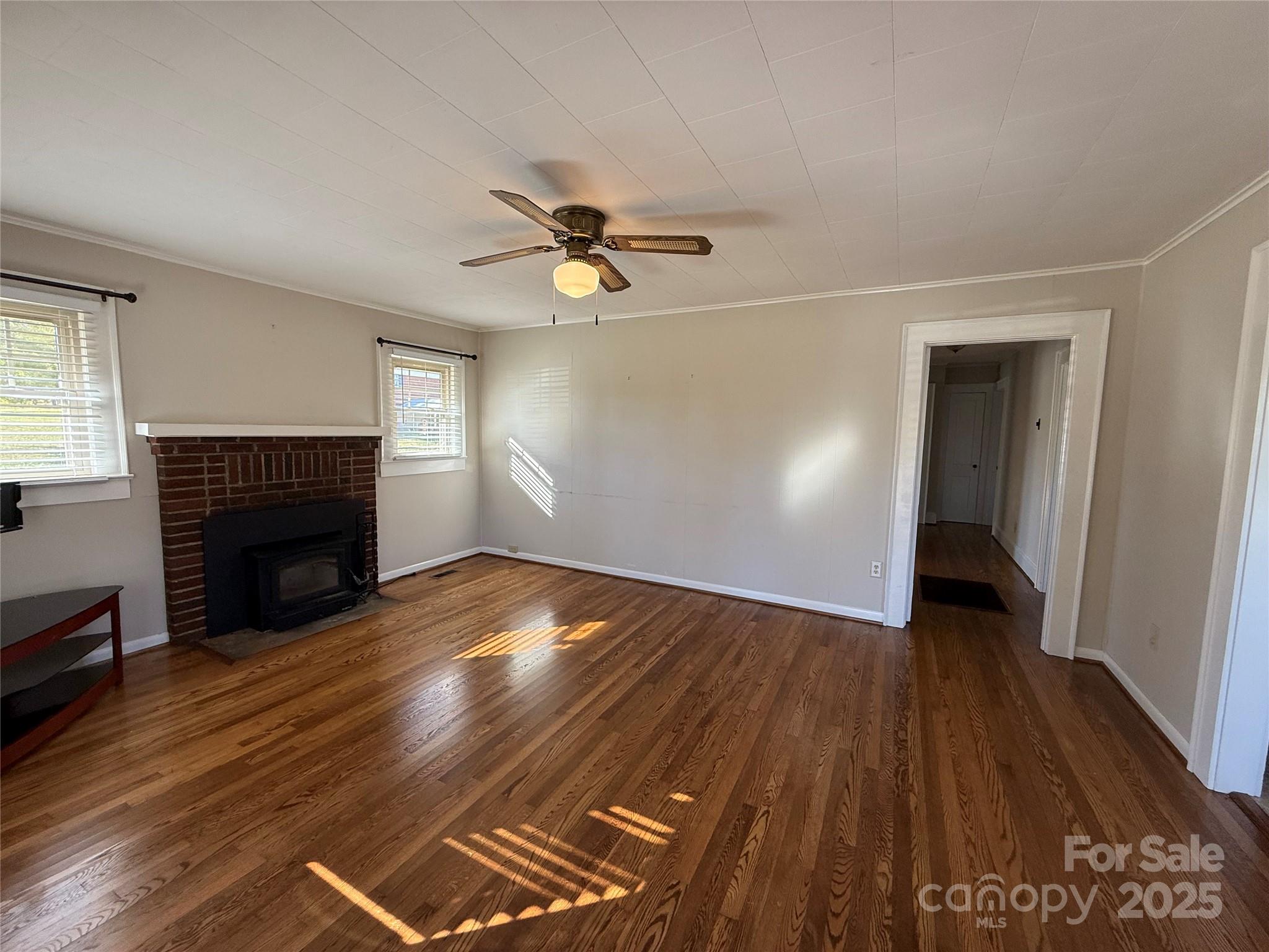 2550 Lail Road Glen Alpine, NC 28655 - Photo 10 of 35 a view of empty room with wooden floor and fireplace