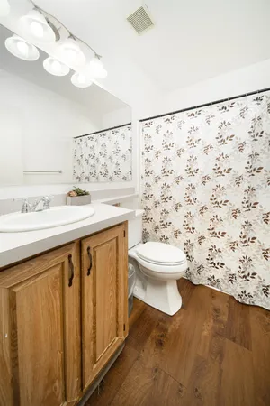 a bathroom with a sink a toilet and shower