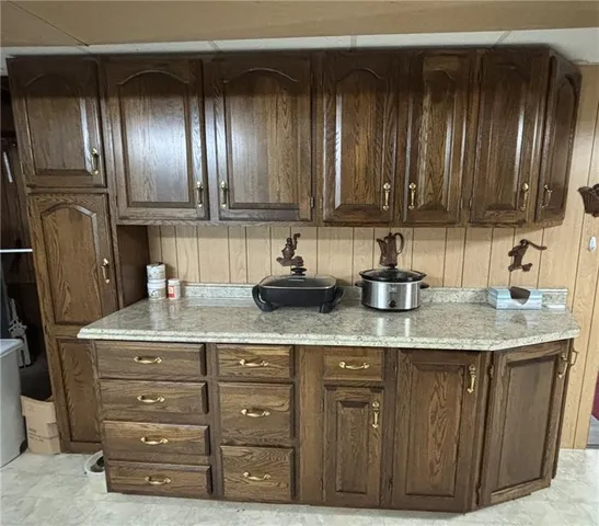 a kitchen with granite countertop stainless steel appliances wooden cabinets and a sink