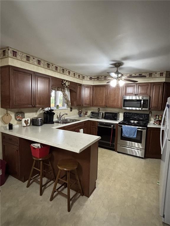 132 Marlene Road Beaver Falls, PA 15010 - Photo 4 of 25 a kitchen with kitchen island stainless steel appliances a sink counter space cabinets and a couch