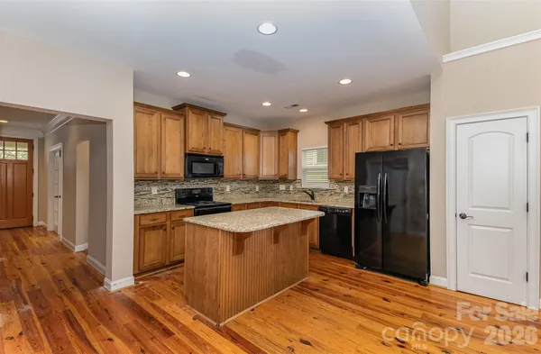 a kitchen with stainless steel appliances granite countertop a refrigerator stove top oven and sink