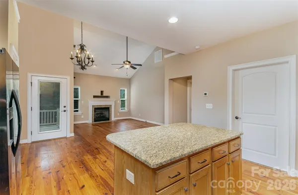 a kitchen with granite countertop a stove and a wooden floors