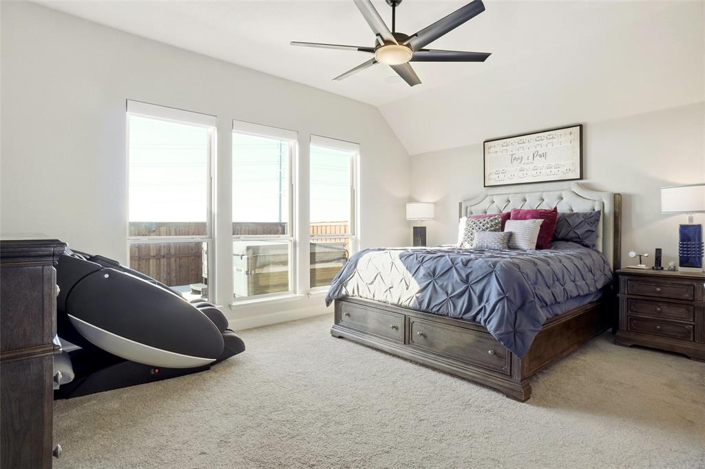 118 Alamito Road Rhome, TX 76078 - Photo 16 of 37 a spacious bedroom with a large bed and a chandelier