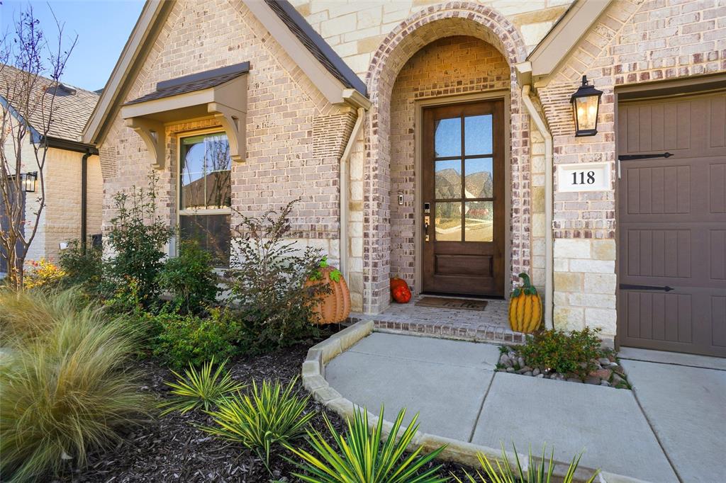 118 Alamito Road Rhome, TX 76078 - Photo 4 of 37 a view of a brick house with a large windows and flower plants