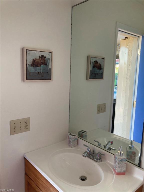 250 Pinehurst Circle Naples, FL 34113 - Photo 23 of 23 a bathroom with a sink and a mirror