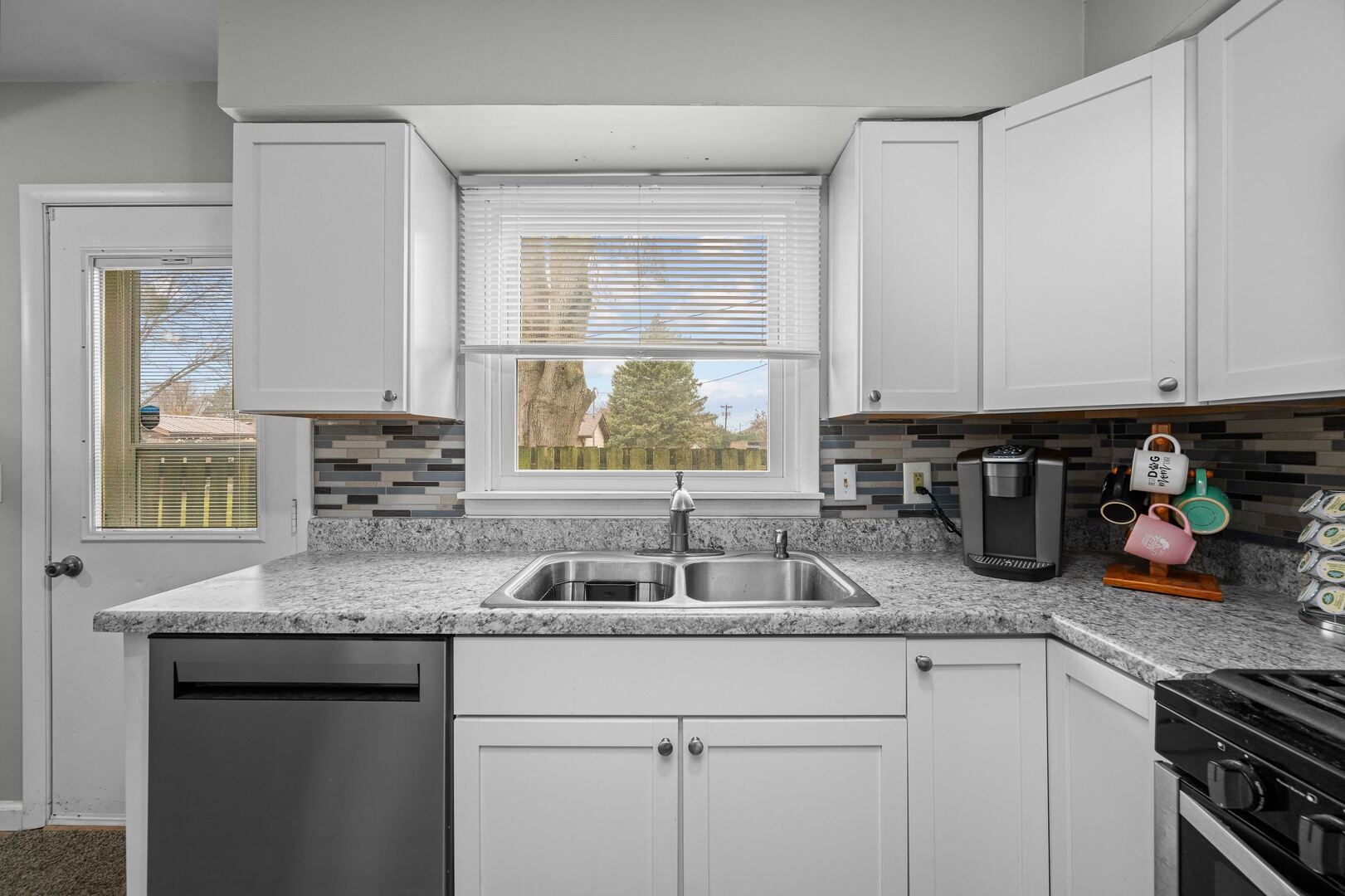 4315 26th Avenue Moline, IL 61265 - Photo 9 of 16 a kitchen with granite countertop stainless steel appliances a sink window and cabinets