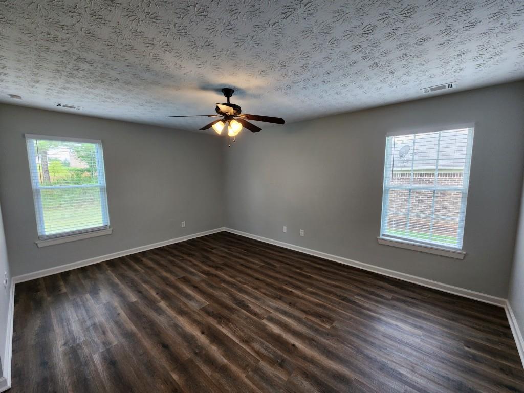 504 Dove Way Social Circle, GA 30025 - Photo 13 of 16 an empty room with wooden floor fan and windows