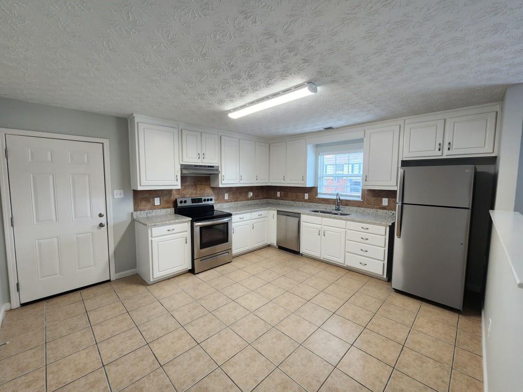 504 Dove Way Social Circle, GA 30025 - Photo 6 of 16 a kitchen with a refrigerator sink and cabinets