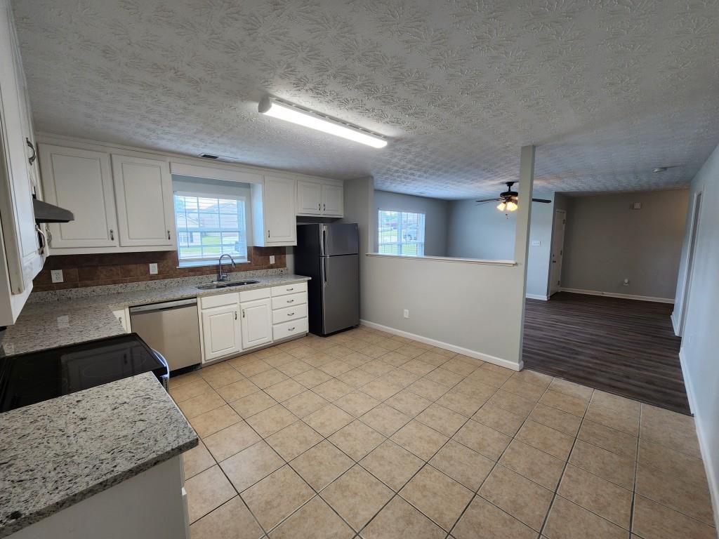 504 Dove Way Social Circle, GA 30025 - Photo 7 of 16 a large kitchen with a stove a sink dishwasher and a refrigerator