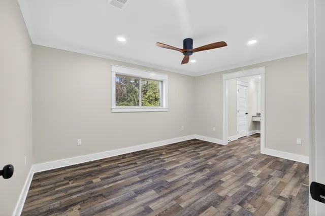 a view of a livingroom with wooden floor and a kitchen