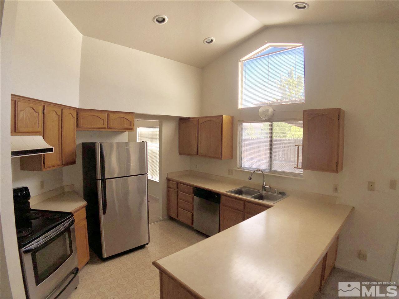 6364 Chesterfield Lane Reno, NV 89523 - Photo 11 of 29 a kitchen with stainless steel appliances a refrigerator a sink a stove a microwave a counter top and cabinets