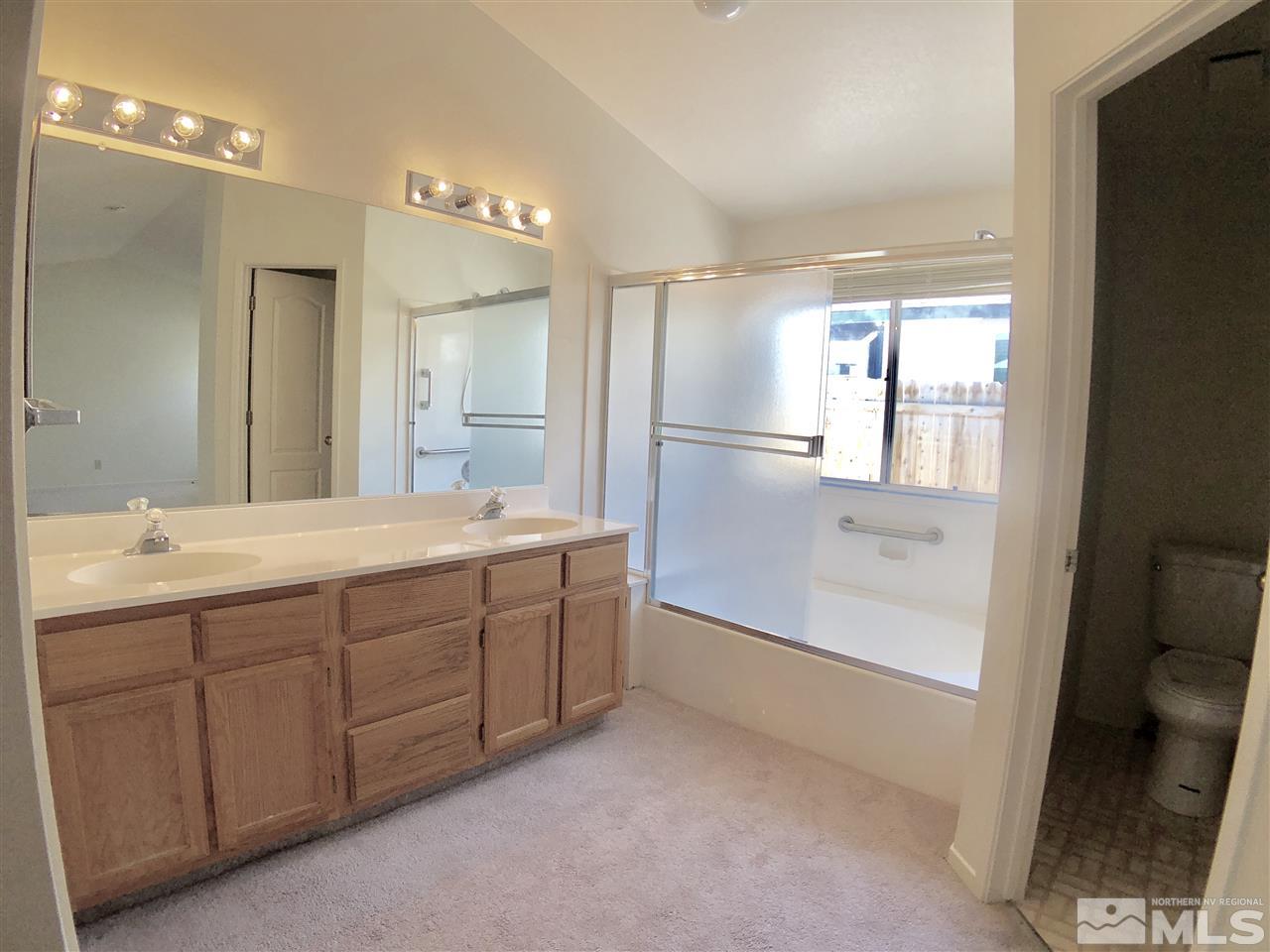 6364 Chesterfield Lane Reno, NV 89523 - Photo 21 of 29 a bathroom with a double vanity sink a toilet and a large mirror
