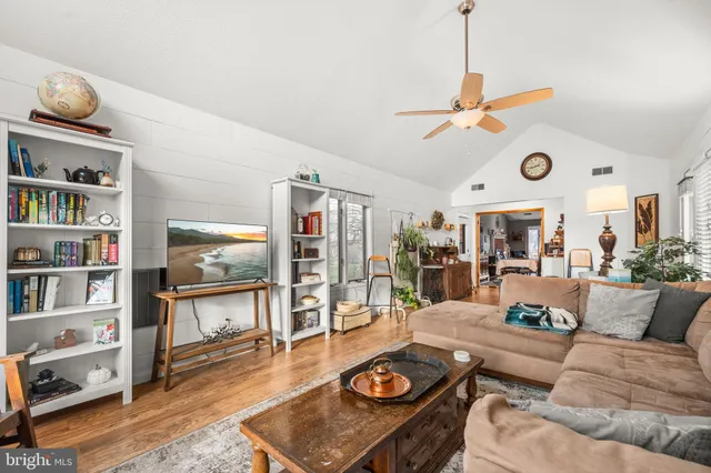 a living room with furniture and a wooden floor