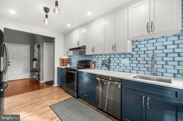 a kitchen with a sink dishwasher a stove a refrigerator and cabinets