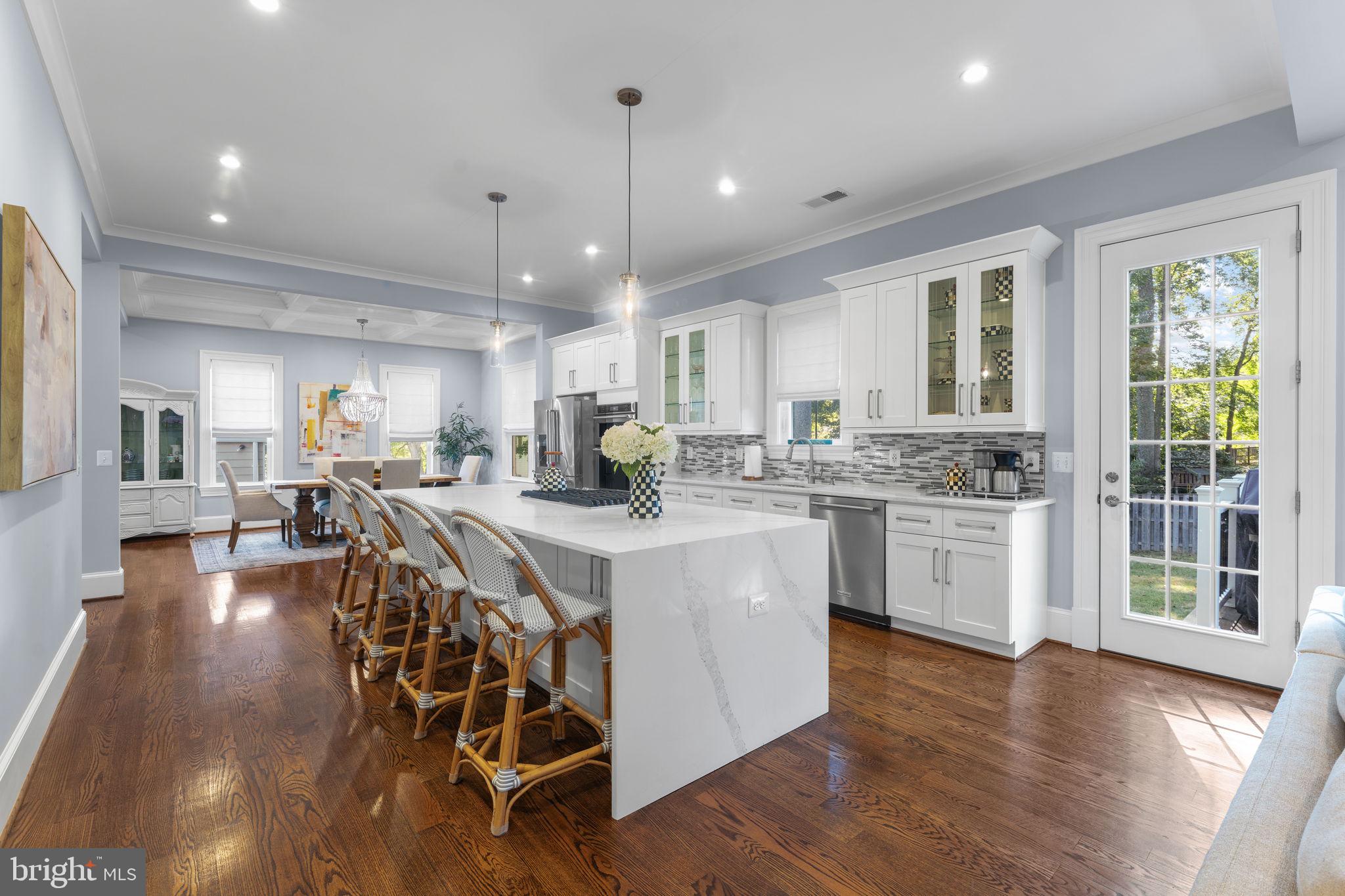 106 Tapawingo Road Southwest Vienna, VA 22180 - Photo 17 of 91 a kitchen with stainless steel appliances kitchen island granite countertop a stove a sink a refrigerator and white cabinets with wooden floor