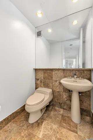 a bathroom with a sink toilet and a mirror
